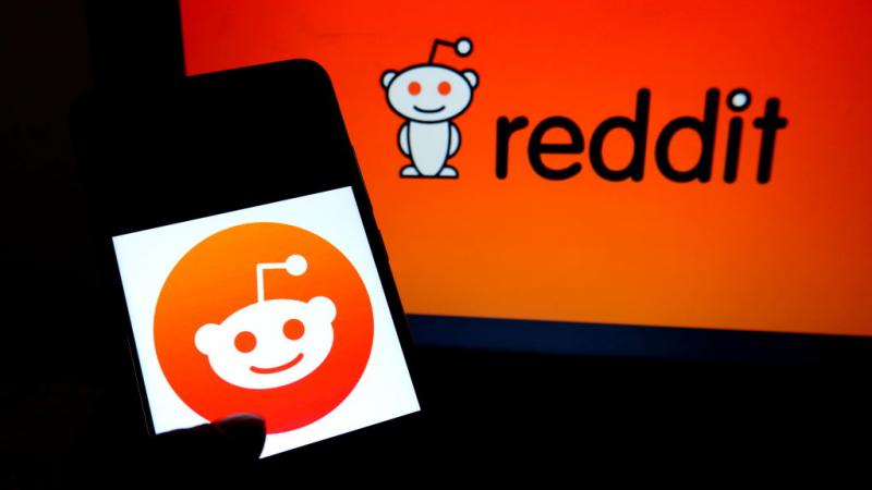 In photo illustration the Reddit logo on displayed on phone