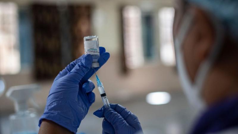A health worker in India prepares a COVID-19 vaccine, Feb. 12